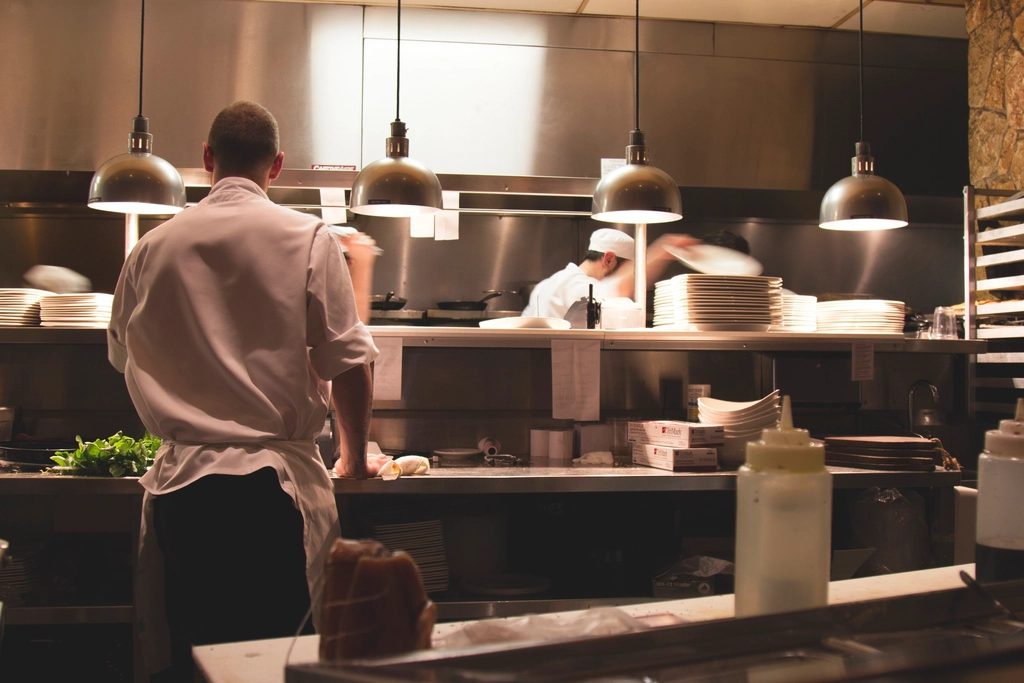 ピークタイムに注文が集中し、厨房のキャパシティが逼迫する飲食店の現場